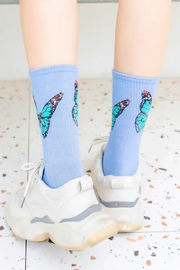 Detailed close-up of blue combed cotton crew socks with elegant butterfly patterns