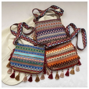 Three bohemian woven crossbody bags with geometric patterns and fringe tassels in various colors