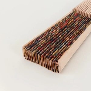 Close-up of a folding fan featuring a colorful Paisley fabric pattern and bamboo ribs