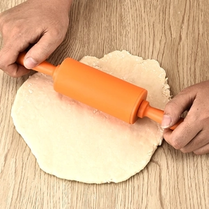 30.5cm large orange non-stick silicone rolling pin used on dough on wooden tabletop