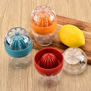 Three colorful manual citrus juicers in orange, blue, and red on a wooden tabletop