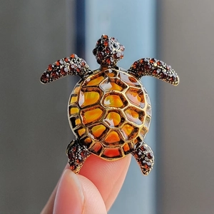 Detailed view of turtle brooch with amber glaze shell and sparkling rhinestones