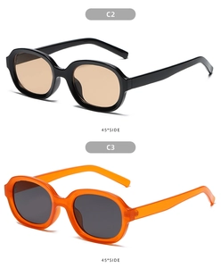 Detail view of oval sunglasses in black with tea lenses and transparent orange frames