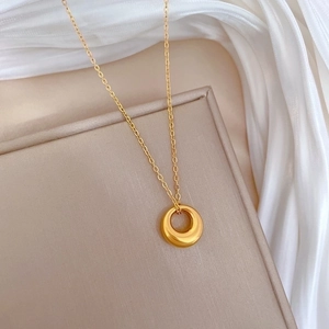 Minimalist gold plated titanium steel necklace with a smooth round pendant on silk
