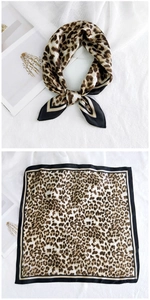 Detail of square silk scarf featuring brown leopard print and black stitched borders