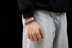 Gros plan d'un bracelet chaîne rétro argenté pour homme porté avec une tenue décontractée