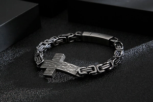 Detailed view of men's Byzantine chain bracelet with a hammered texture cross charm
