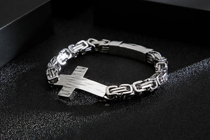 Close-up of silver titanium steel cross bracelet with hammered texture and Byzantine chain