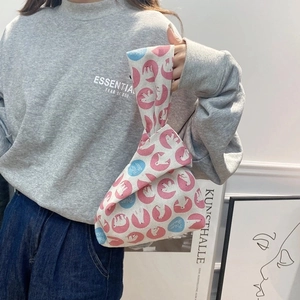 Detail of linen wrist bag with polar bear print and asymmetric knotted handle closure