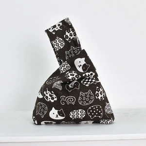 Detailed close-up of dark brown linen wrist bag with white cat patterns in Japanese style