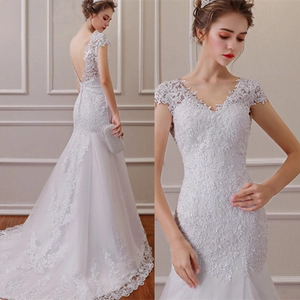 White lace mermaid wedding dress with a deep V-neck, open back, and long elegant train