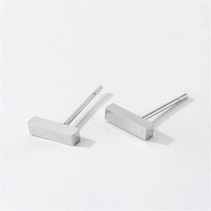 Macro shot of minimalist silver stainless steel rectangular geometric stud earrings