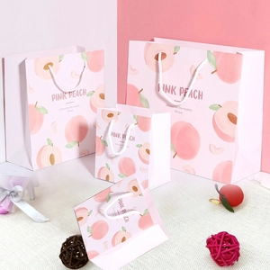Detailansicht der rosa Pfirsich-Geschenktüten in vier Größen mit weichen Griffen