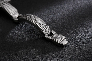 Detailed close-up of retro engraved patterns on a wide stainless steel punk style bracelet