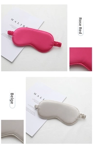 Detail of rose red and beige silk sleep masks with elastic bands and smooth texture