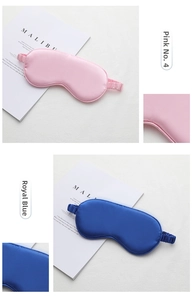 Detailed view of pink and royal blue silk sleep masks with elastic headbands on white paper