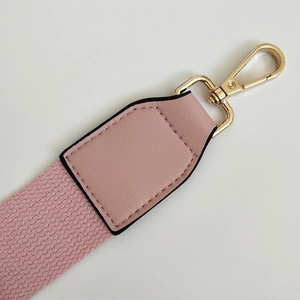 Detail of pink canvas strap with premium leather ends and golden lobster clasps