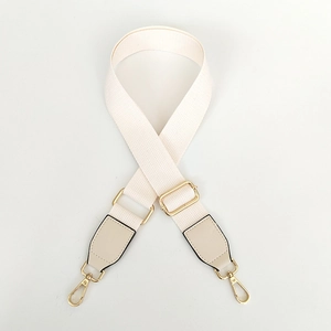Detail of adjustable cream canvas strap with gold metal buckles and khaki leather ends