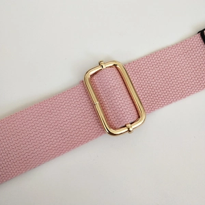 Detail of pink canvas strap featuring a polished gold adjustable metal buckle