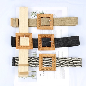 Three woven straw belts with square wooden buckles in beige, black, and herringbone pattern