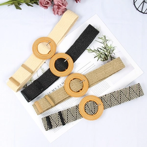 Detail view of woven belts in multiple colors with natural round wooden buckles