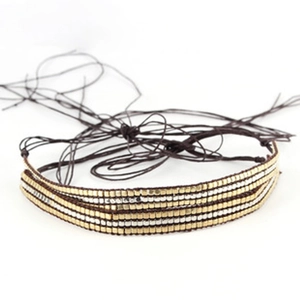 Macro detail of multi-strand braided jute rope with gold and silver metallic beads
