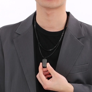 Detail of double-layer men's necklace with black square pendant on leather and metal cord
