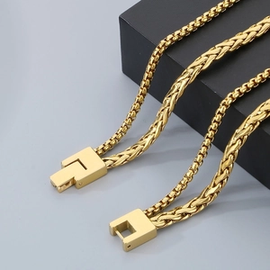 Macro shot of gold box and wheat chains with secure square clasp detailing