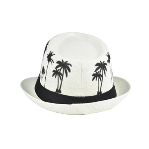 Detailed view of white woven fedora hat featuring black coconut tree embroidery and band