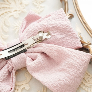 Close-up of pink oversized layered bow hair clip back with silver metal spring fastener
