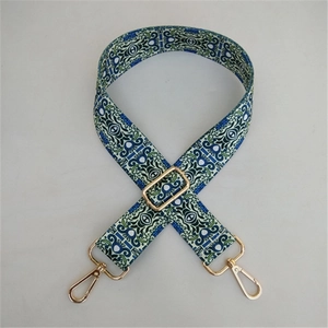 Detail of adjustable blue and green ethnic pattern bag strap with gold metal buckles