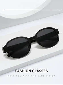 Detail of matte black oval sunglasses featuring wide temples on a white geometric stand