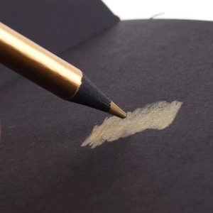 Metallic gold pencil on black paper with high coverage and shining luster effect