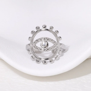 Macro shot of silver evil eye open ring with white zircon on a white background