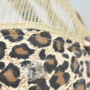 Vue détaillée du tissu imprimé léopard et des coutures en maille beige sur une casquette