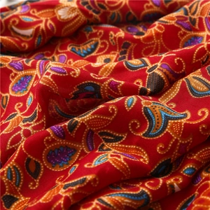 Close-up of red Bohemian ethnic scarf with intricate paisley patterns and linen texture