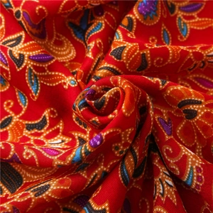 Ethnic bohemian red cotton linen scarf with vibrant floral print in spiral fold