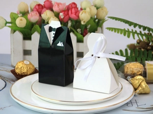 Creative wedding candy boxes featuring groom tuxedo and bride dress on a floral dining plate