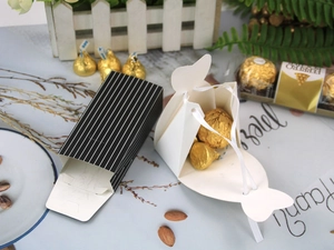 Detail of tuxedo-style wedding favor boxes with ribbon and striped pattern design