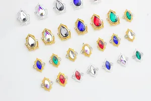 Macro shot of colorful teardrop and marquise rhinestones in gold and silver nail art settings