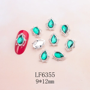 Detail of 9x12mm emerald teardrop nail charm with silver hollow filigree and vintage base