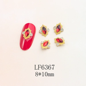Detail of red marquise crystal nail art charm with golden vintage relief frame and small studs