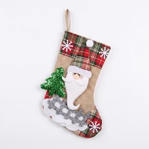 Close-up of red linen Christmas stocking with 3D Santa Claus and green glitter tree