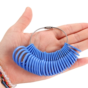Close-up of blue plastic ring sizer gauges on a steel cable held by a person