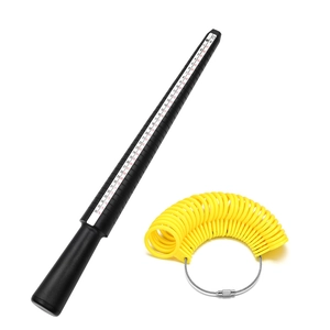 Detail of black plastic ring sizer mandrel and yellow finger gauge rings with size scales
