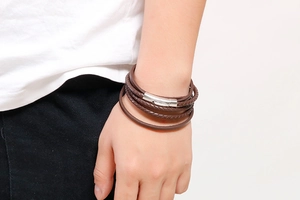 Close-up of brown multi-layer braided leather bracelet with silver cylinder metal clasp