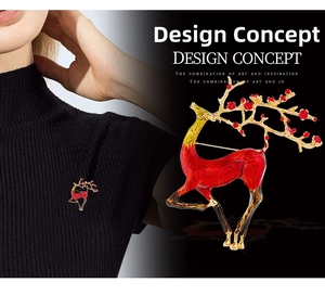 Detail of elegant gold-plated enamel elk brooch with red floral accents on antlers