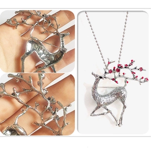 Detail of silver elk brooch with red floral accents on antlers shown from multiple angles