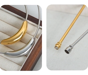 Detail of gold and silver magnetic clasp closure on geometric snake bone chain necklace