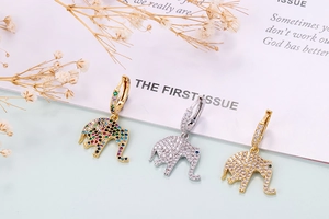 Macro shot of small elephant earrings featuring colorful zircon stones on gold and silver base